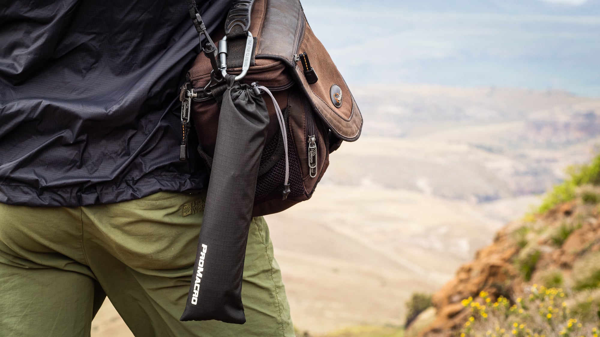 Person with a black drawstring pouch and camera bag