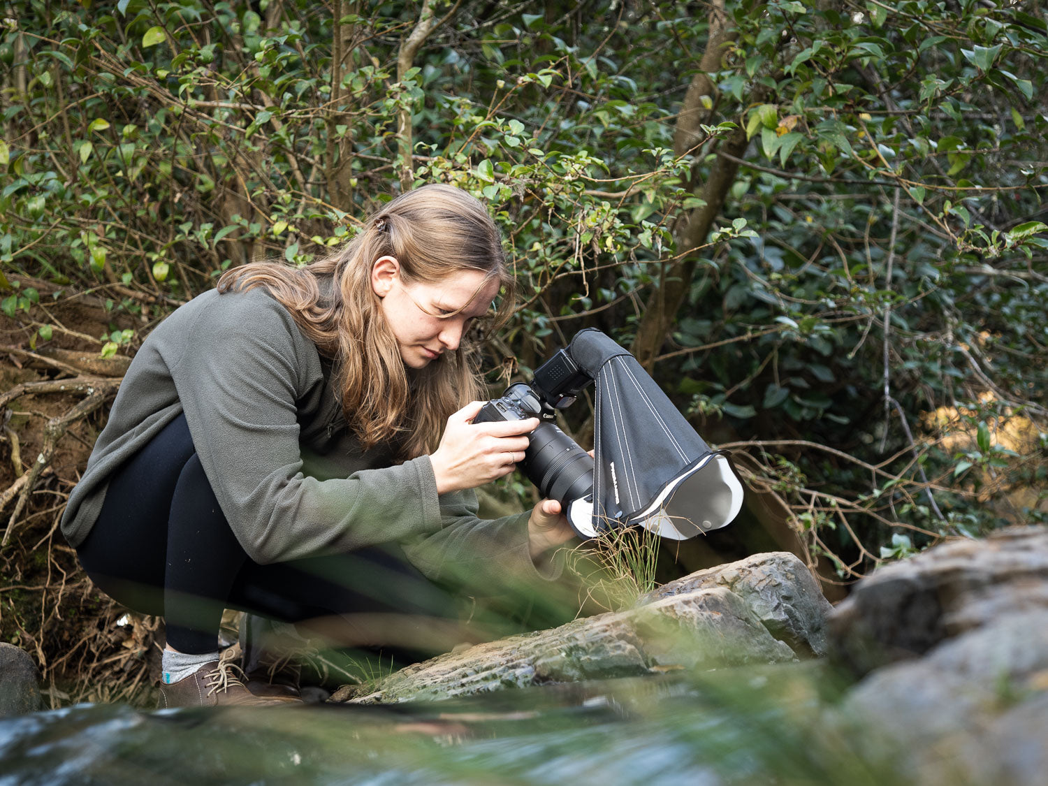 Person taking a photo with a camera and macro diffuser in a natural setting