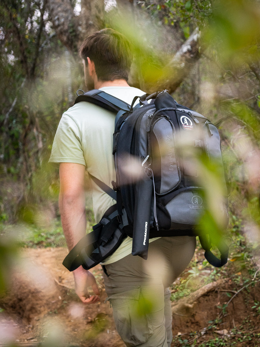 Person hiking with a black backpack in a forest with promacro diffuser